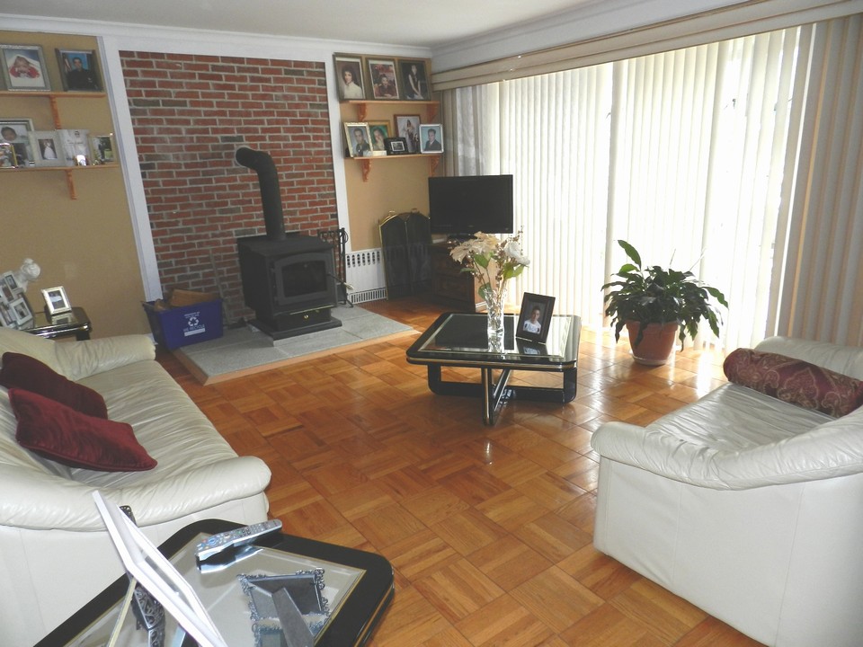 living room with hardwood floor and wood burning stove